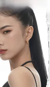 Close-up of minimalist gold bar earrings on a model showing a high-polish mirror finish