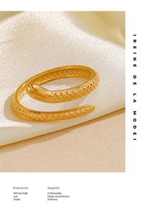 Detail of vintage snake ring with textured scales and golden finish on silk fabric
