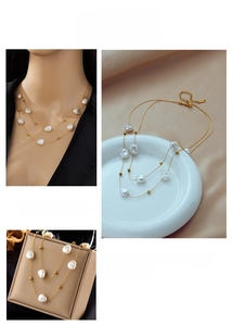 Detail of double-layer titanium steel necklace with baroque pearls and gold beads