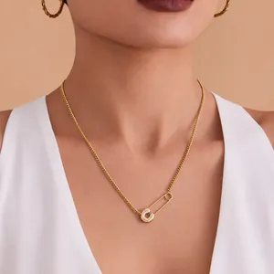 Detail of 18k gold plated safety pin necklace with micro-paved cubic zirconia letter C