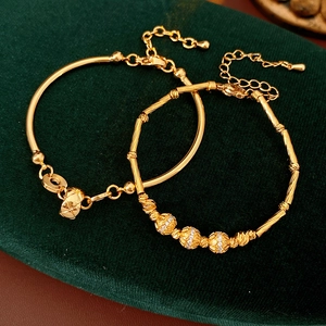 Detail of 18K gold plated bamboo link bracelet with zircon beads on green velvet box
