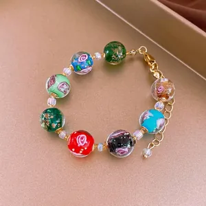 Elegant beaded bracelet with colorful floral patterns and gold-tone adjustable chain