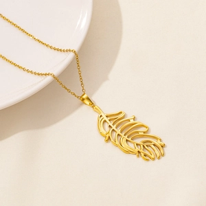 Macro shot of gold leaf pendant on cross chain necklace over beige fabric backdrop