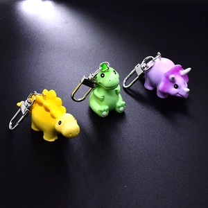 Three cute colorful cartoon dinosaur resin keychains in yellow green and purple