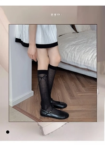 Detail of black ribbon bow socks showing vertical striped texture and ballet style