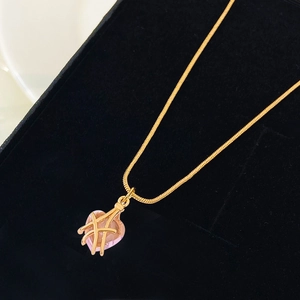 Collar con colgante de corazón de cristal rosa y líneas cruzadas doradas en cadena