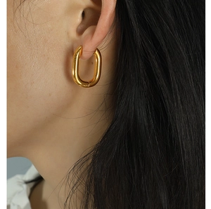Close-up of elegant gold U-shaped chunky hoops worn by a model for a chic look