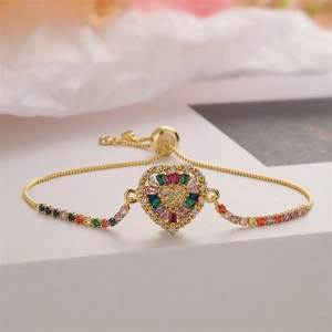 Detail of heart charm bracelet with rainbow stones and adjustable gold chain