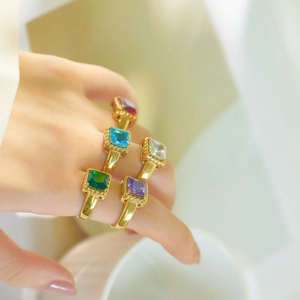 Stackable gold stainless steel rings with colorful square-cut zircon stones on model's hand