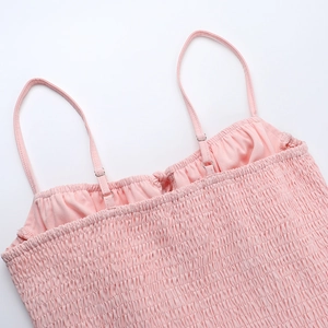Gros plan d'une robe rose à fronces avec bretelles réglables et tissu extensible texturé