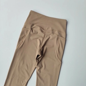 High-waisted yoga leggings with side pockets in earth-tone elastic compression fabric