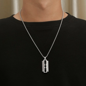 Close-up of hip hop silver blade pendant necklace with CZ stones on a male model
