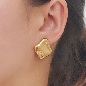 Makroaufnahme von unregelmäßigen Goldohrringen im Liquid-Metal-Stil mit Hochglanzpolitur