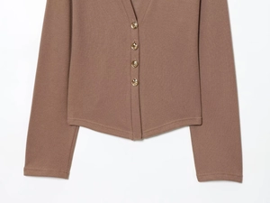 Close-up of brown ribbed knit cardigan featuring four elegant gold circular buttons