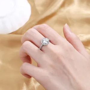 Macro shot of halo engagement ring with round center diamond and pavé band on silk