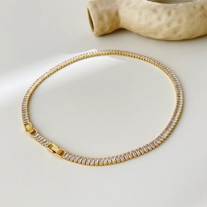 Macro view of 18k gold plated tennis necklace featuring rectangular zircon stones and clasp