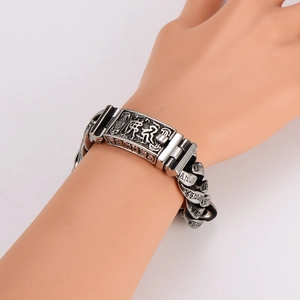 Detail of vintage silver punk bracelet with engraved Buddhist mantras for men
