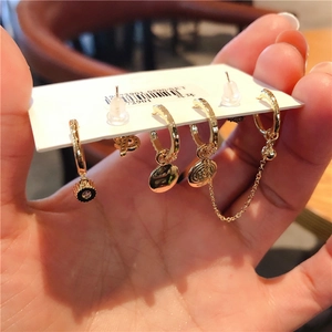 Detailed view of 6-piece golden earring set with color zircon on display card