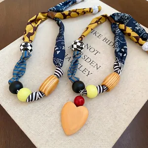 Collier artisanal en tissu avec pendentif coeur fleuri et perles acryliques mixtes