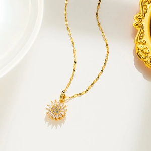 Nahaufnahme der drehbaren Sonnenblumenkette mit funkelnden Kristallen auf Goldkette