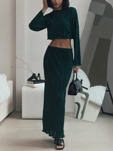 Elegant dark green pleated set with long-sleeved crop top and high-waisted maxi skirt