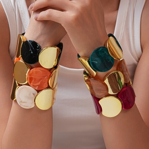 Dettaglio di segmenti in resina colorata e lega dorata sul bracciale largo elastico