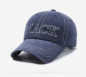 Dettaglio del cappellino da baseball in denim lavato blu navy con ricamo MACK bianco
