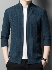 Detail of teal knit cardigan featuring stand collar, zip closure and textured patterns