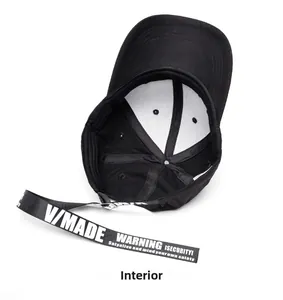 Internal detail of a black baseball cap featuring a long strap with warning text prints