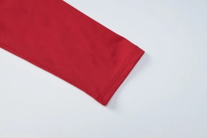 Détail de la manche d'une robe rouge en maille montrant la double surpiqûre et la texture