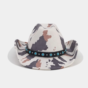 Detail of cow print western cowboy hat with turquoise beads and metal studs on black band