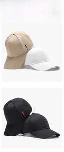 Detail of embroidered cross design on twill cotton baseball caps in khaki and black
