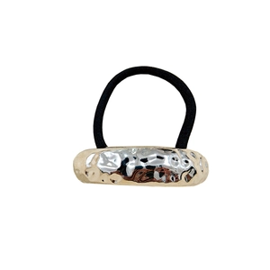 Detail of geometric metal hair tie with gold and silver irregular textured finish
