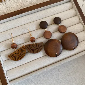 Boucles d'oreilles ethniques en perles de bois au design éventail ajouré sur plateau