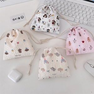 Detail showing four assorted cartoon drawstring pouches for makeup and small items