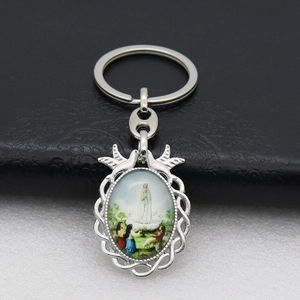 Detailed silver religious keychain featuring Our Lady of Fatima on a textured leather background