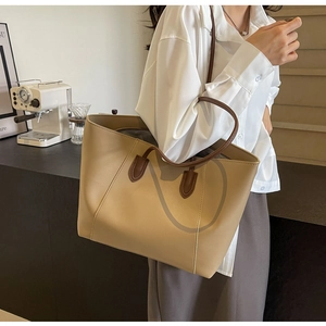 Close-up of khaki faux leather tote bag with brown straps for elegant commute look