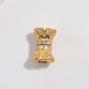 Detail of gold double-layer hourglass bead with sparkling white cubic zirconia stones