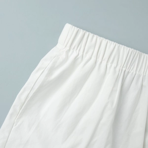 Gros plan détaillé du short en coton blanc montrant la taille élastique et les poches