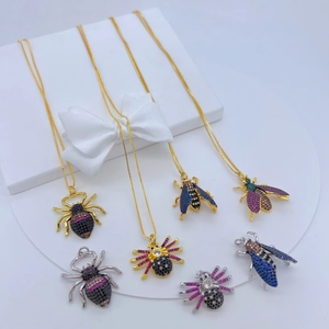 Close-up of insect insect pendant with colorful gemstones on a white gift box