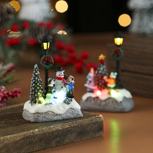Illuminated Christmas resin house scene with snowman, LED tree, and glowing bokeh effect
