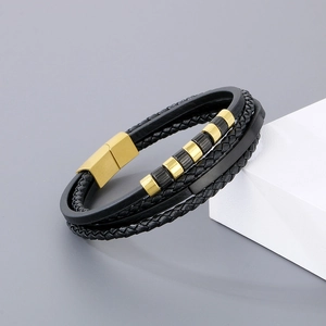 Macro detail of men's multilayer braided leather bracelet with gold magnetic metal clasp