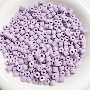 Dettaglio macro di perline cilindriche acriliche viola da 6mm con foro per gioielleria