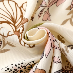 Macro view of light twill fabric featuring elegant tropical floral prints and soft texture