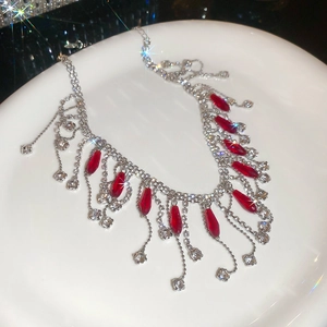 Detailed macro view of crystal tassel necklace with deep red teardrop stones