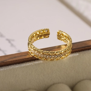 Detail of adjustable gold-plated ring with hollow heart design and sparkling zircon stones