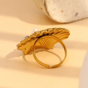 Macro view of adjustable 18K gold shell ring with pearl and sparkling crystals