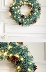 Close-up of artificial pine needles and warm LED lights on a Christmas wreath
