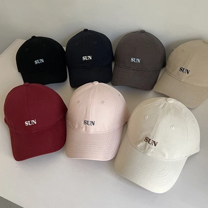 Detailed flat lay of cotton baseball caps in seven colors with sun letter embroidery