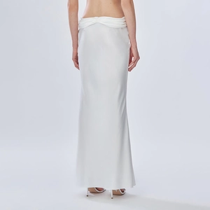 Détail d'une jupe longue en satin blanc avec taille plissée et texture de tissu brillant